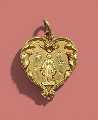 an image of a gold heart shaped pendant on a pink background