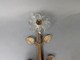 a glass flower on the wall with spoons and spoon rest