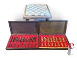 two boxes with chess pieces in them on a white surface