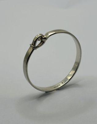 a close up of a silver ring with a knot on it