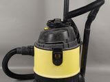 un aspirateur jaune et noir muni d'une poignée noire
