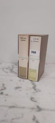 deux boîtes de parfum posées sur un plan de travail en marbre