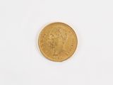 a close up of a gold coin on a white surface