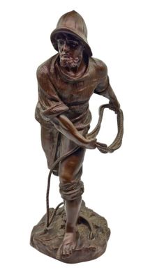 statue en bronze représentant un homme muni d'un fouet et portant un chapeau