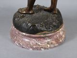 a bronze statue of a man standing on top of a rock