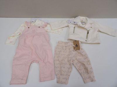 deux vêtements de bébé et une veste posés sur une table blanche