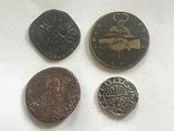 four different types of coins sitting on top of a white surface