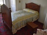 a bed with a yellow comforter in a room