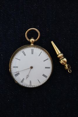 une montre de poche en or à laquelle est attachée une chaîne