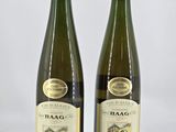 two bottles of wine sitting next to each other on a white surface