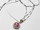 un gros plan d'un collier orné d'une pierre rose