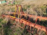 a tractor that is sitting in the grass near a field