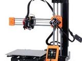 une image d'une imprimante 3D orange et noire posée sur une table