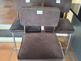 three chairs sitting on a tiled floor in front of a fire place