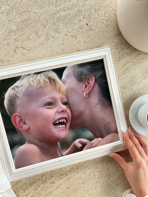 une femme tenant une photo d'un enfant et une tasse de café