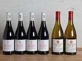 six bouteilles de vin sont alignées sur une table en bois