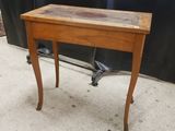 une vieille table en bois avec un plateau en bois et des pieds en métal