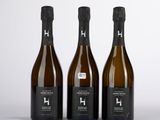 trois bouteilles de vin posées l'une à côté de l'autre sur une table