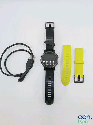 a black watch and a yellow strap on a white surface