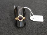 gros plan d'une bague sur une surface noire avec une étiquette de prix