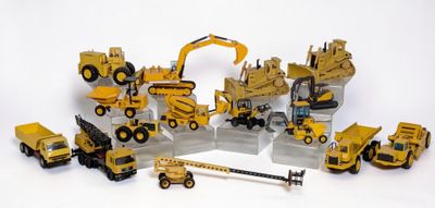 des véhicules de chantier miniatures sont disposés en cercle sur une surface blanche