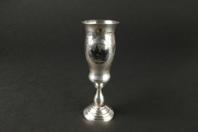 un gobelet en argent posé sur une table noire