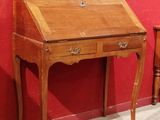 un petit bureau muni d'un tiroir, placé devant un mur rouge