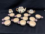 une image représentant un ensemble de tasses et une théière posées sur une table