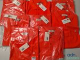 six t-shirts rouges avec leurs étiquettes, posés sur une table