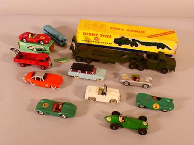 Plusieurs petites voitures et camions sont alignés sur une surface blanche