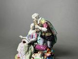figurine of a man and a woman sitting on a chair
