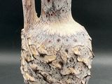 a white vase with a bird on it on a table