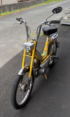 a small yellow bike parked on the side of the road