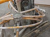 a machine that is sitting on the ground with a hose attached to it