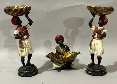 three figurines of women with baskets on their heads