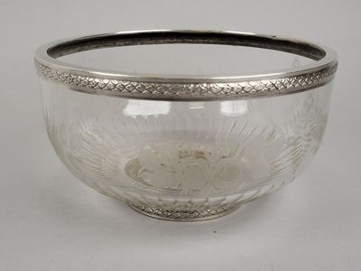 un bol en verre bordé d'argent posé sur une table