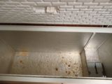 a dirty refrigerator with a dirty door and a dirty floor