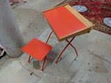 une table orange et deux chaises sur le trottoir