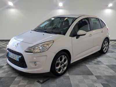 la petite voiture blanche est garée sur un sol en damier