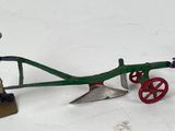 a figurine of a man plowing a field with a plow