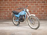 a blue motorcycle parked in front of a brick wall