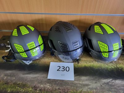 trois casques ornés d'autocollants, posés les uns à côté des autres