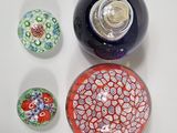 three different colored glass balls sitting on a white surface