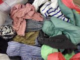 a pile of clothes in a box on the floor