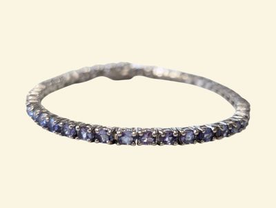 a close up of a silver ring with blue sapphire stones