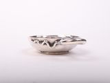 a close up of a small silver bowl on a white surface