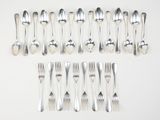 many forks and spoons laid out on the table