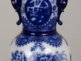 a blue and white vase sitting on a wooden table