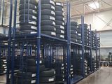 a lot of tires stacked on a rack in a warehouse