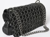 the black purse has a chain around it and is on a white surface